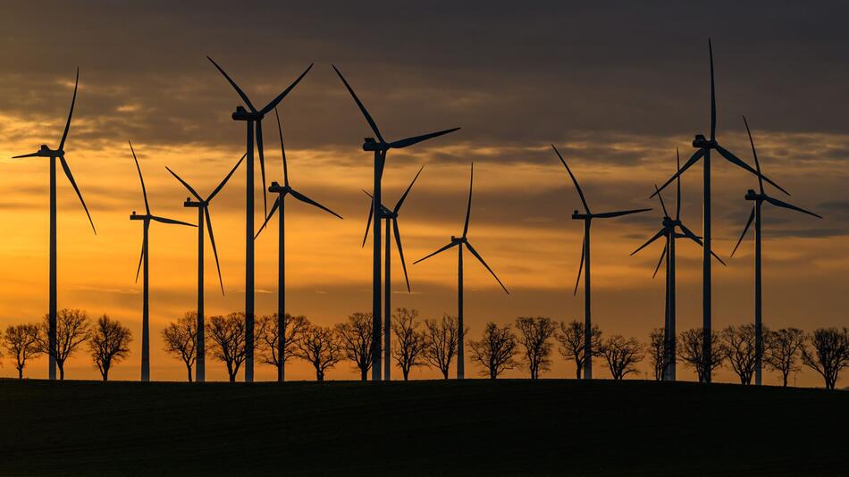 Windräder in einem Windpark bei Sonnenaufgang