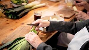 Eine Seniorin schneidet Lauch klein