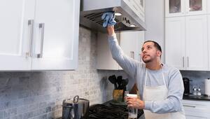 Mann reinigt Dunstabzugshaube