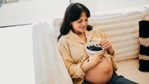 Junge Schwangere Frau isst Blaubeeren