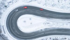 Autos fahren bei winterlichem Wetter eine Serpentine entlang