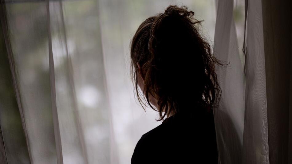 Eine Frau steht am Fenster
