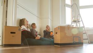 Drei Frauen sitzen gut gelaunt zwischen Umzugskisten