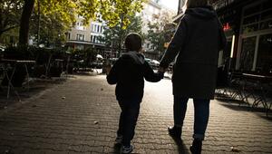 EineFrau hält ein Kijd an der Hand