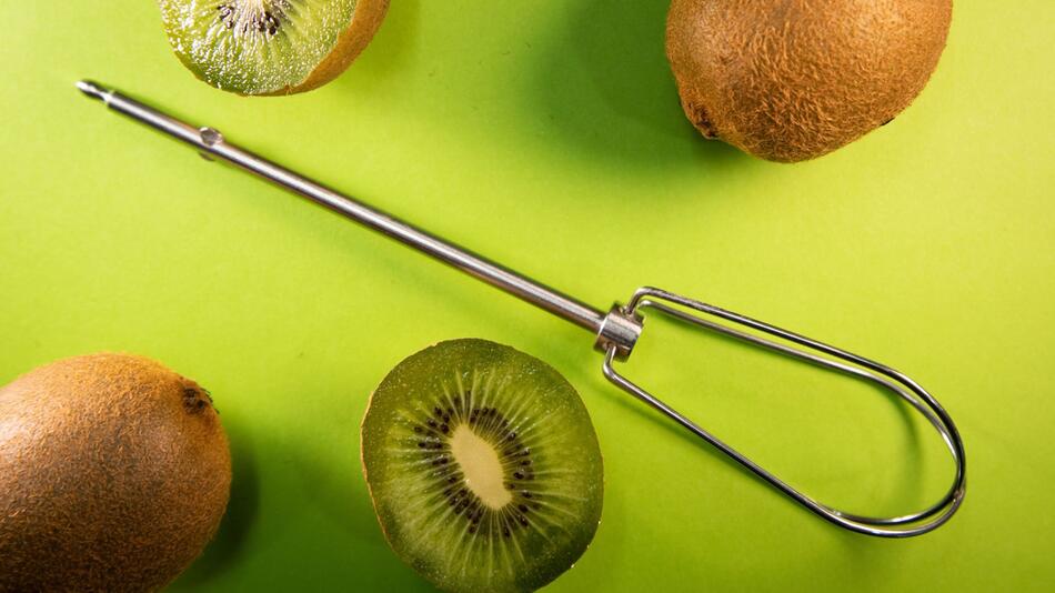 Kiwis liegen neben einem Rührbesen-Aufsatz
