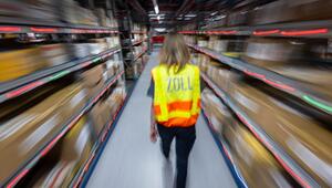 Eine Zollbeamtin läuft durch ein Paketlager