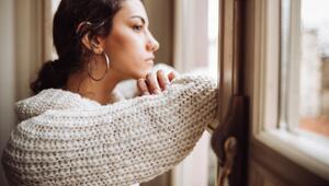 Junge Frau nachdenklich am Fenster