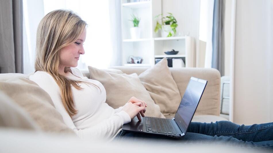 Frau sitzt vor einem Laptop