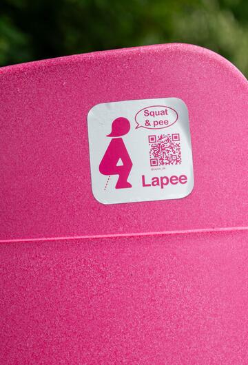 Knallpinkes Frauenpissoir mit „Squat & pee – Lapee“-Sticker bei Rock im Park 2025