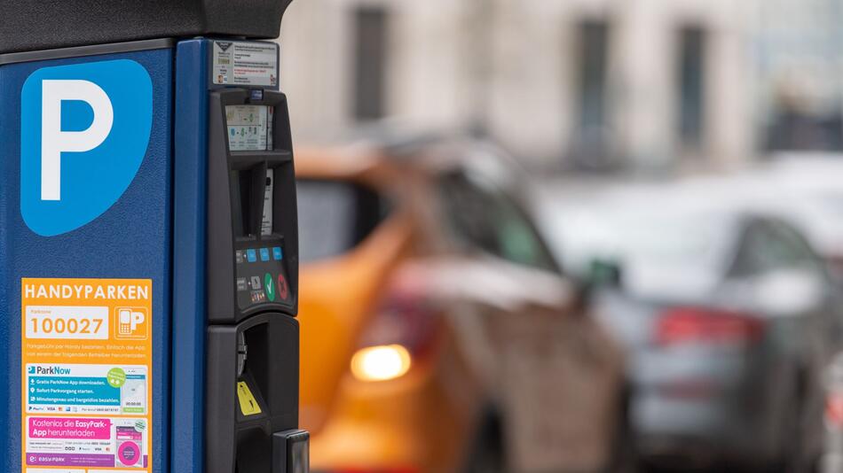 Parkscheinautomat steht vor parkenden Autos am Straßenrand