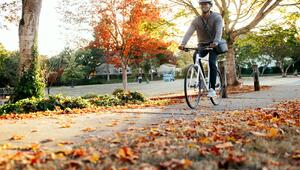 Junger Mann radelt im Herbst auf der Straße