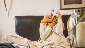 Eine Frau mit einer Erkältung auf einem Sofa