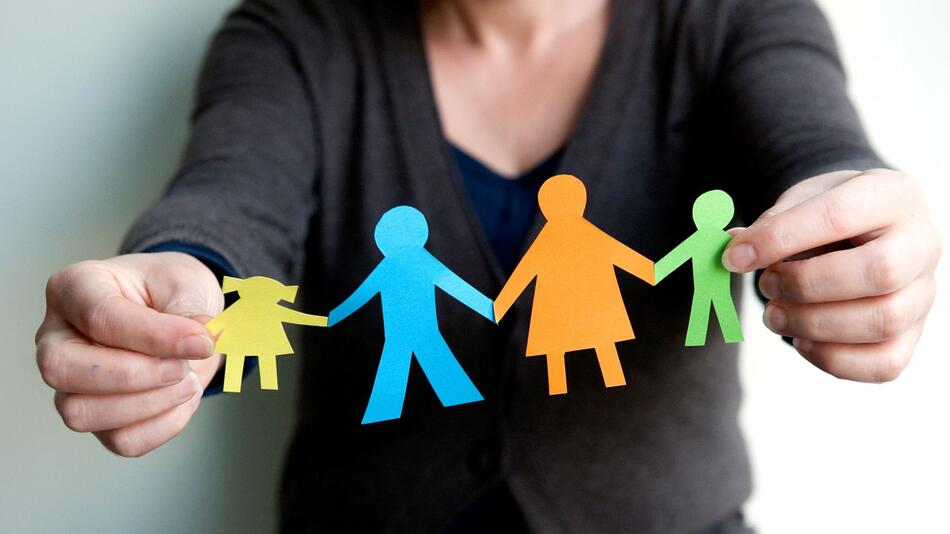 Eine Frau hält eine Familie aus buntem Papier