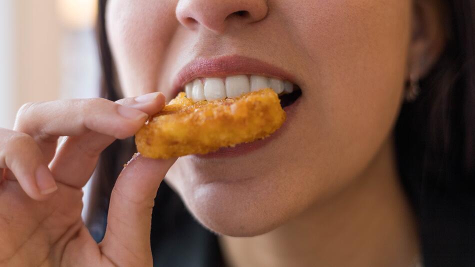 Frau isst Nugget