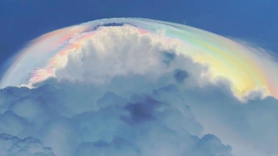 Wie ein Heiligenschein: Regenbogenwolke leuchtet über Sturmwolken
