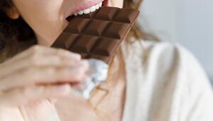 Frau beißt genüsslich in eine Tafel Schokolade