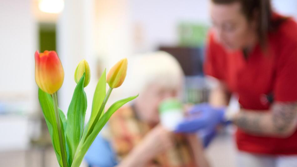 Symbolbild: Eine Pflegekraft unterstützt eine Seniorin beim Frühstück