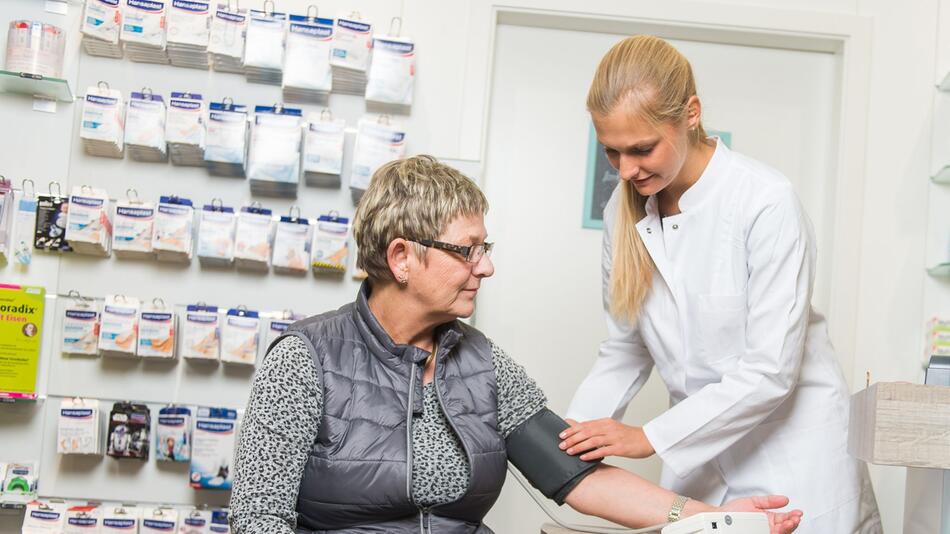 Apothekerin misst den Blutdruck einer Kundin
