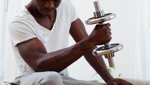 Mann trainiert mit Kurzhanteln mit Gewichtsscheiben