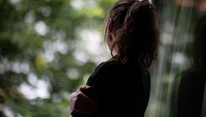 Frau steht am Fenster