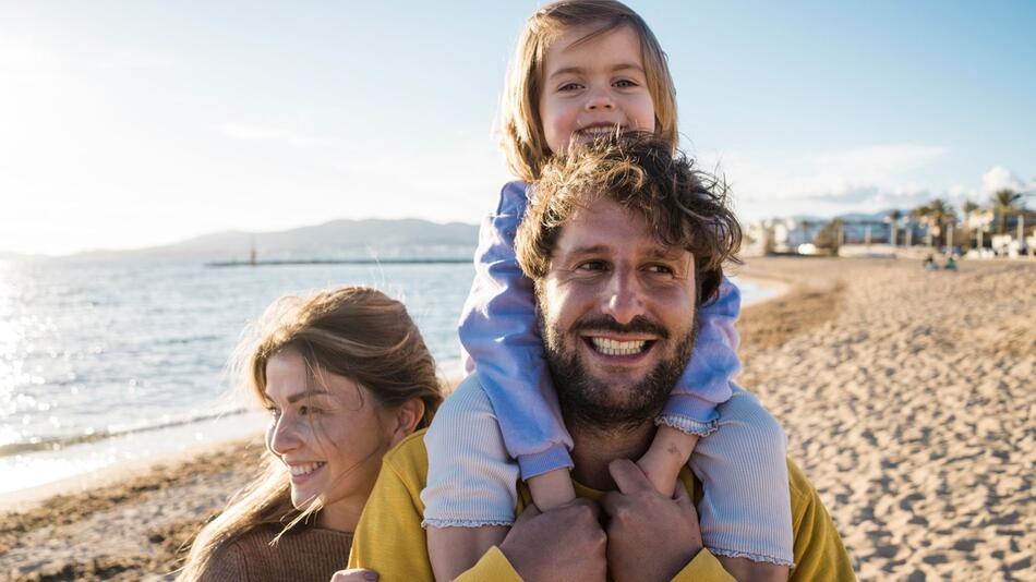 Familie läuft am Strand entlang
