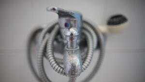 Naaufnahme eines verkalkten Duschhahns mit Schlauch.