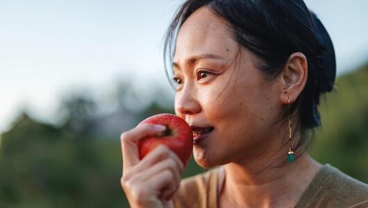 Frau, die in Apfel beißt. 