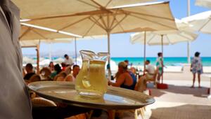Kellner serviert am Strand einen Wein