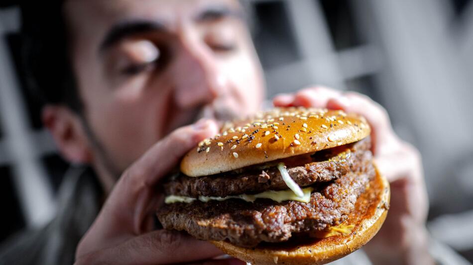 Mann beißt in einen Burger
