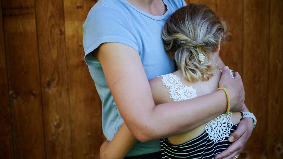 Ein Mädchen seine Mutter in den Arm