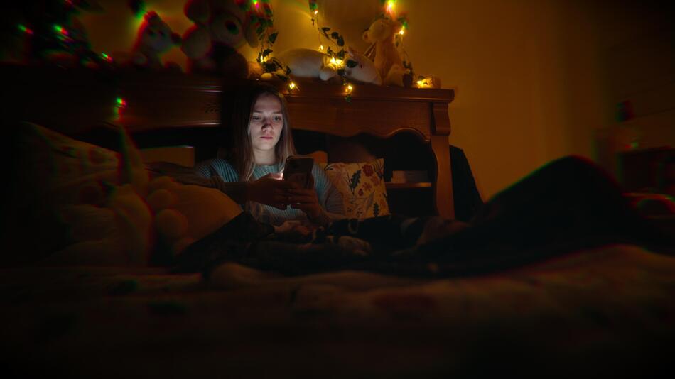 Lauryin sitzt auf ihrem Bett.