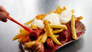 Eine Currywurst mit Pommes und Mayo