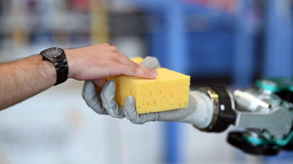 Ein Humanoider Roboter ARMAR-6 hält einen Schwamm in der Hand