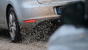 Ein Auto fährt auf der nicht geräumten Straße durch Schneematsch