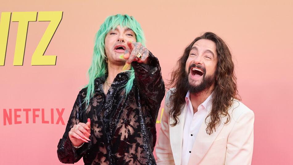 Bill und Tom Kaulitz lachen auf dem roten Teppich