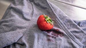 Eine Erdbeere liegt auf einem T-Shirt