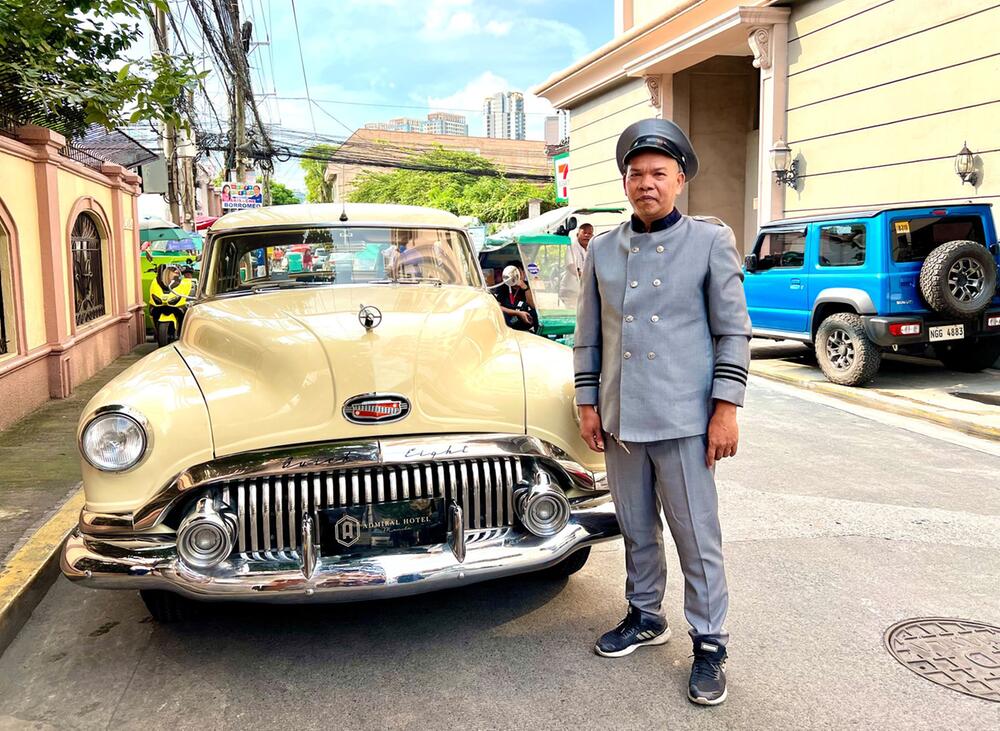 Chauffeur vor dem Oldtimer in Manila