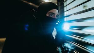 Maskierter Einbrecher mit Taschenlampe (Symbolbild)