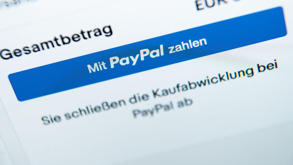 Der Schriftzug "Mit PayPal zahlen" auf einem Laptop