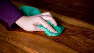 Eine Frau reinigt einen Holztisch